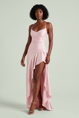 Abito lungo rosa in raso con schiena stringata e gonna asimmetrica con volant
