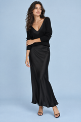 Abito maxi in raso nero con scollo asimmetrico e dettagli di piume