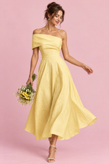 Abito giallo asimmetrico con spalle scoperte