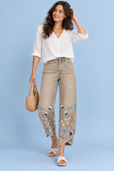 Pantaloni beige con stampa floreale e spacco all’orlo